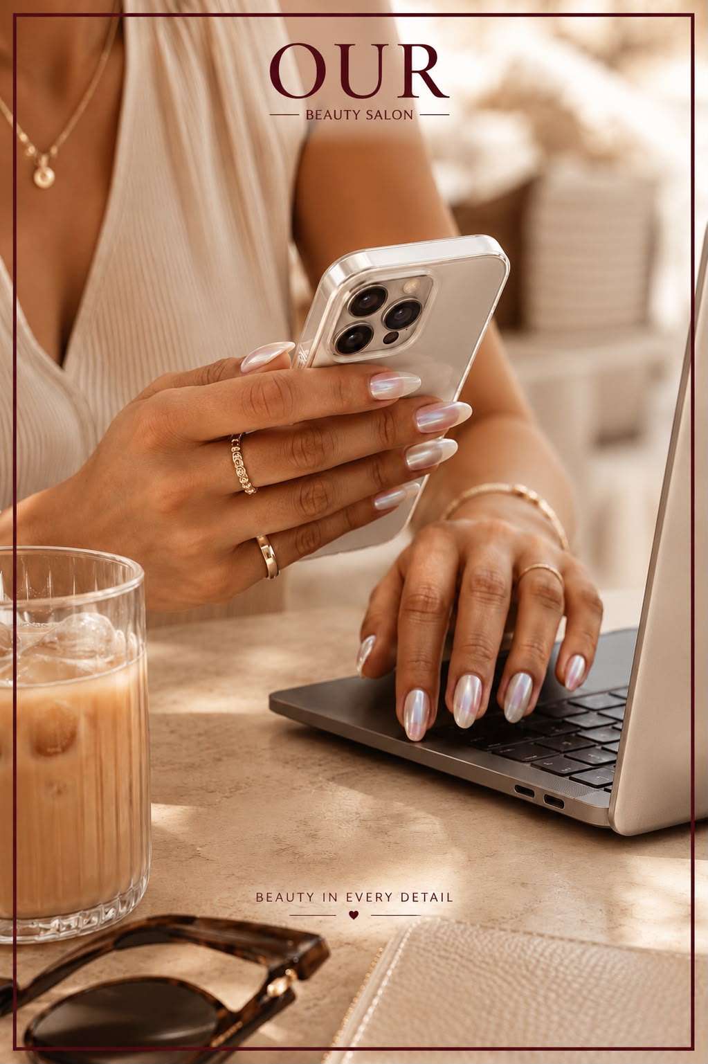 Iridescent chrome almond nails styled with gold jewellery at a marble desk